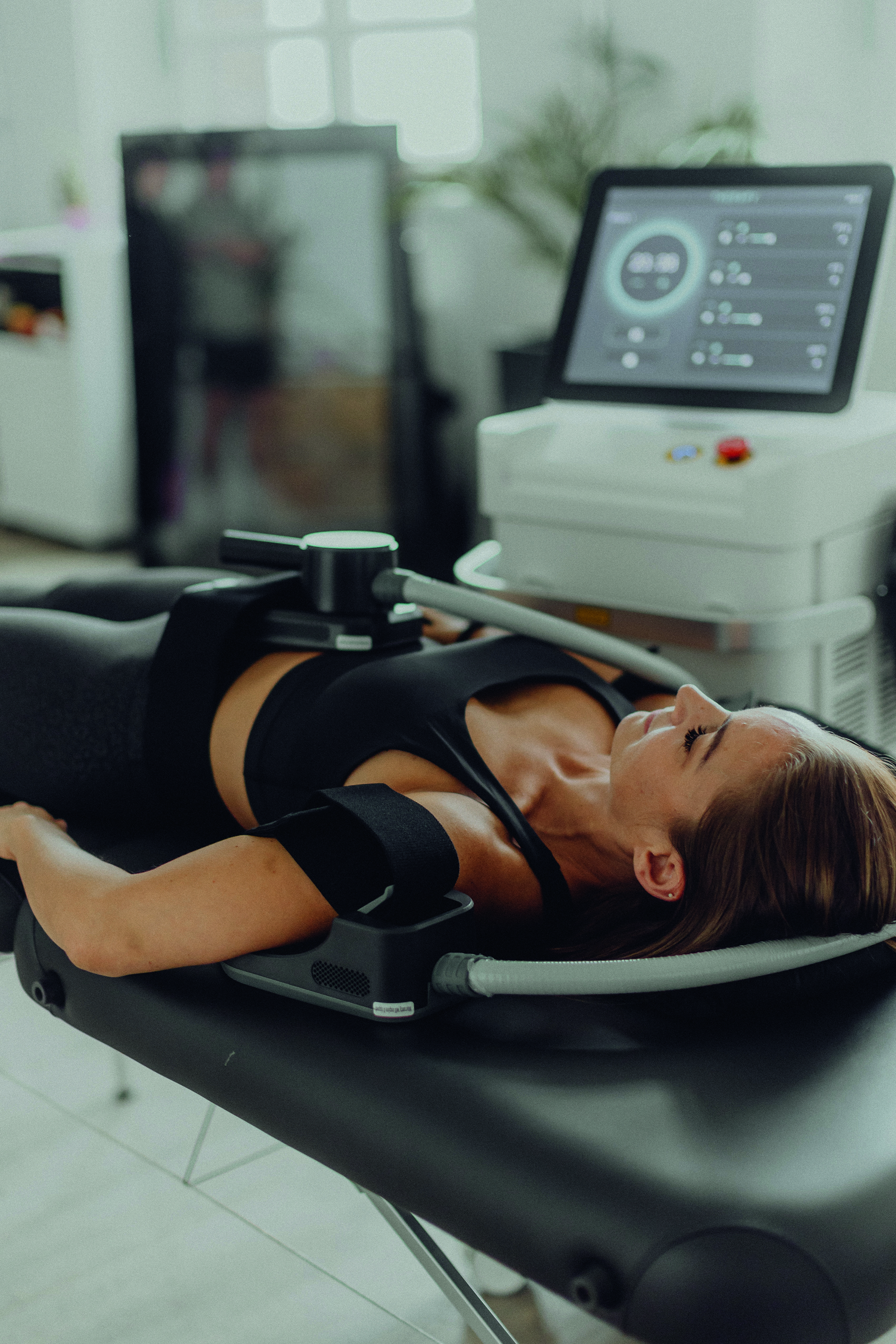 Frau entspannt im Liegen auf dem EMP Body Contouring Gerät